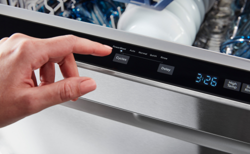 Person selecting cycle on a dishwasher.